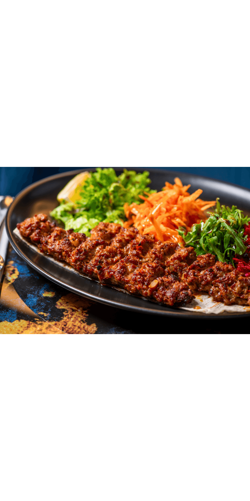 Grilled lamb skewers with herbs on a wooden board