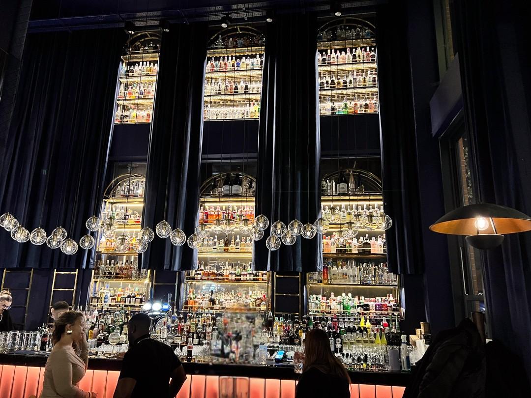 The bar at Opuz Aylesbury with bottles and amber lighting