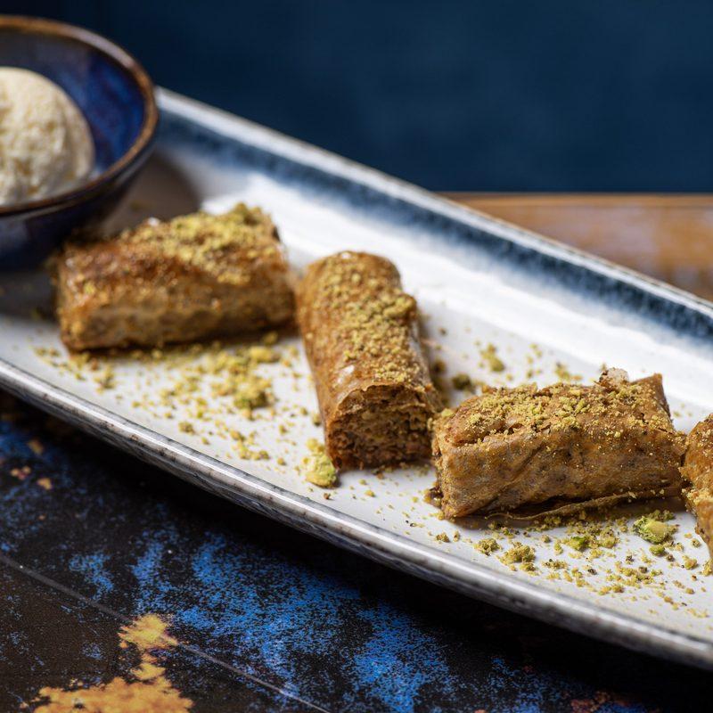 Layers of pistachio baklava served warm with Madagascan vanilla ice cream